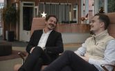Två kollegor sitter i en lounge och diskuterar kursmarknadsföring via nyhetsbrev.