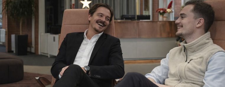 Två kollegor sitter i en lounge och diskuterar kursmarknadsföring via nyhetsbrev.
