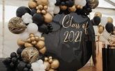 Dekorationer för studentskiva med ballongbåge i guld och svart.